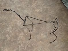 a wire horse sculpture sitting on the floor