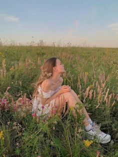 a woman sitting in the middle of a field