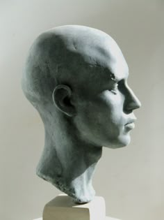 a statue of a man's head is shown in black and white, against a plain background