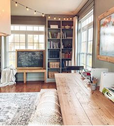 a living room filled with furniture and bookshelves next to a large wooden table