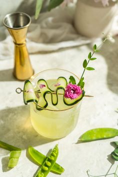 a drink with cucumbers and flowers in it