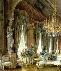 an ornate living room with chandeliers and furniture