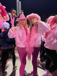 two girls dressed in pink posing for the camera