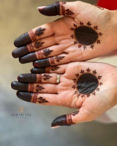 two hands with hendi designs on them, one is black and the other is brown