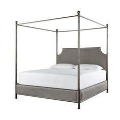 an iron bed frame with white sheets and pillows on it, against a white background