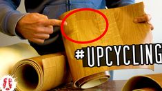 a man holding up a piece of wood with the words upcycling on it