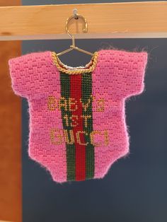 a pink sweater hanging from a wooden hanger