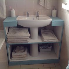 a bathroom with a sink, towel rack and toiletries on the shelf in front of it