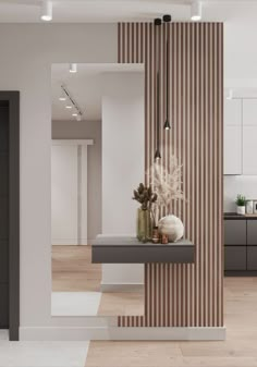 a modern kitchen with white walls and wood flooring, along with an open area for seating