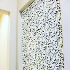 an intricately designed wall panel is shown in the corner of a room with white walls