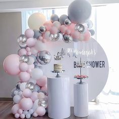 the balloon arch is decorated with silver, pink and white balloons for a baby shower