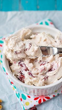 a bowl filled with ice cream sitting on top of a colorful napkin next to a spoon