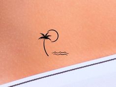 a small palm tree on the back of a woman's stomach