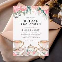 an elegant bridal tea party with pink flowers on the table and envelopes next to it