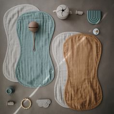 two baby bibs, pacifiers and other items laid out on the floor