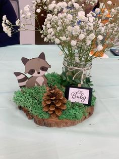 a vase filled with flowers sitting on top of a wooden stump next to a sign