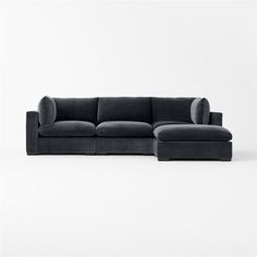 a black sectional couch sitting on top of a white floor