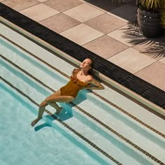 a woman in a bathing suit is floating in a swimming pool