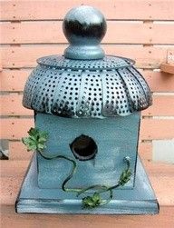 a blue birdhouse with a hole in it's roof sitting on a wooden table