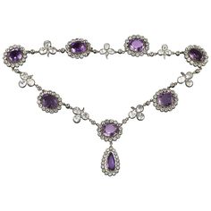 A late Victorian amethyst and rock crystal necklace, the seven oval-shaped amethysts surrounded by a cluster of round-cut rock crystal set in silver to yellow gold, each cluster separated with a rock crystal folitate trefoil, the centre cluster suspending a pear-shaped amethyst and rock crystal drop,the amethysts estimated to weigh 60 carats in total, mounted in gold and silver, circa 1880, measuring approximately 40 x 2.2cm, gross weight 62.5grams. A gorgeous and dramatic amethyst and crystal n Luxury Purple Round Necklace, Vintage Amethyst Necklace, Formal Multi-stone Amethyst Necklaces, Formal Amethyst Multi-stone Necklace, Formal Multi-stone Amethyst Necklace, Amethyst Oval Multi-stone Necklace, Oval Amethyst Multi-stone Necklaces, Oval Amethyst Multi-stone Necklace, Amethyst Rock