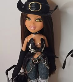 a doll with long hair wearing a black hat