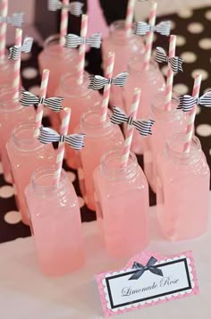 there are many pink drinks in mason jars with black and white striped straws on them