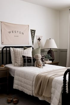 a bedroom with a bed, two lamps and a teddy bear