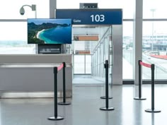 an airport terminal with several turns and barrier posts in front of the doors that are open