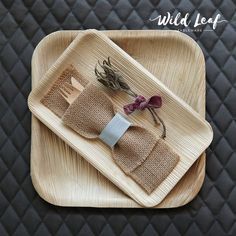 two wooden trays with napkins and flowers on them