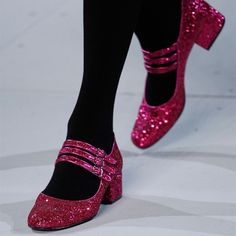 a person wearing pink glitter shoes and black tights