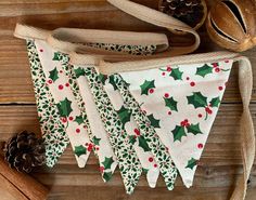 three christmas decorations are hanging on a wooden table next to pine cones and cinnamon sticks