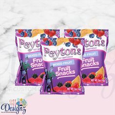 three bags of frozen fruit snacks sitting on top of a marble countertop next to each other