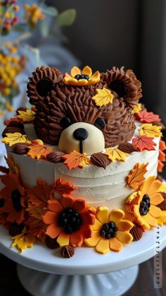 a cake decorated with flowers and a teddy bear