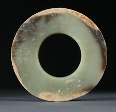 a circular object made out of marble sitting on a table next to a black background