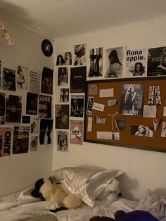 a bedroom with pictures on the wall and a teddy bear laying on it's bed