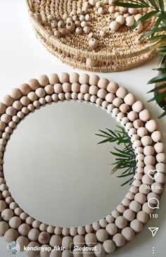 a round mirror sitting on top of a table next to a potted palm tree