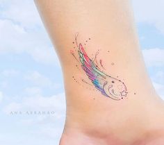 a woman's foot with a colorful tattoo on the side of her body and an angel wing