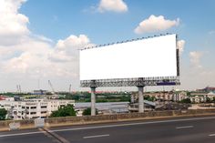 an empty billboard sitting on the side of a highway