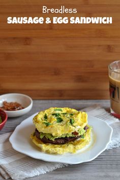 an egg sandwich on a white plate next to a cup of coffee and a glass of orange juice