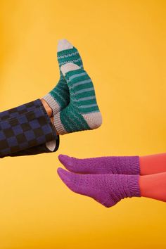 two people wearing socks and one is holding an object in the air with both hands