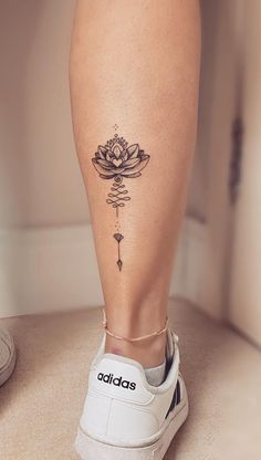 a woman's leg with a lotus tattoo on the lower part of her leg