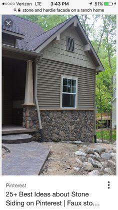 a house that has some rocks in front of it and a stone walkway leading up to the door