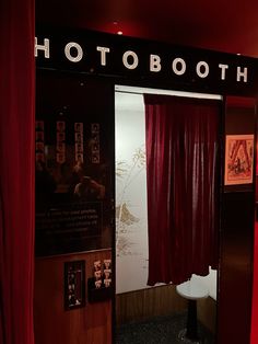 a red curtain is open in front of a photo booth with pictures on the wall