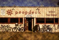 several bicycles are parked in front of a building with the word poopdeck written on it