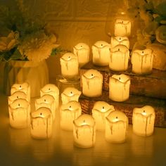 many lit candles are arranged on a table