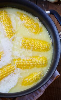 corn on the cob is being cooked in a pot with water and salt inside