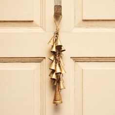 a bunch of bells hanging from the side of a door