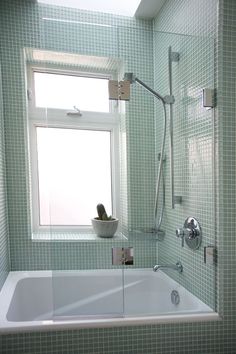 a bath tub sitting next to a window in a bathroom