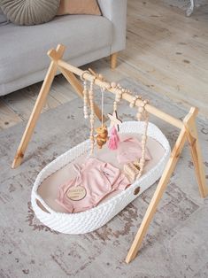 a baby's pink outfit is in a white hammock on the floor