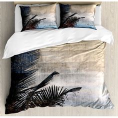 a bed with two pillows on top of it and palm trees in the background,